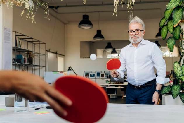 IMAGO Creative: Business - Work-Life Balance Businessman playing table tennis with coworker at office model released, Symbolfoto property released, MEUF07154