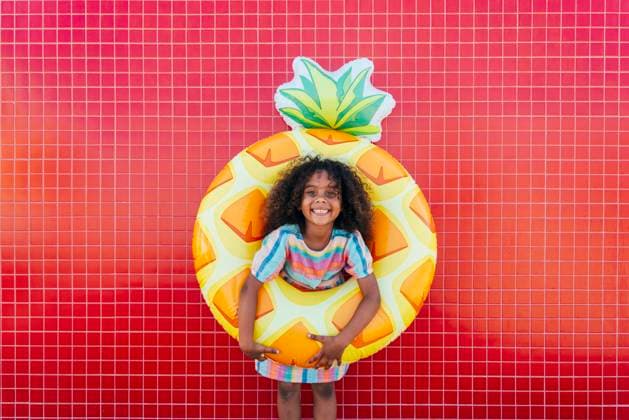 Cute girl wearing swimming float standing in front of red wall model released, Symbolfoto, OIPF02207