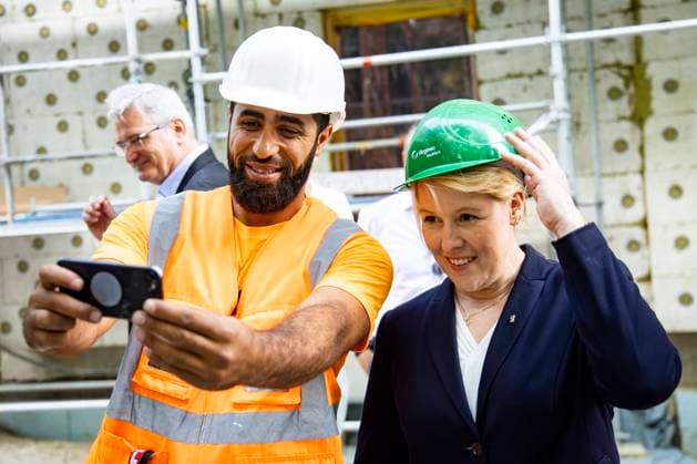 Die Regierende Buergermeisterin Franziska Giffey (R) posiert fuer einSelfie mit Bauarbeiter Joseph Ali (L) beim Besuch der Wohnbauprojekt der DEGEWO am Friedrich-Kayssler-Weg in Neukoelln in Berlin am 25. August 2022. Buergermeisterin Giffey und Bausenator Geisel auf Neubautour in Berlin *** The Governing Mayor Franziska Giffey R poses for a selfie with construction worker Joseph Ali L during a visit to the housing project of DEGEWO at Friedrich Kayssler Weg in Neukoelln in Berlin on August 25, 2022 Mayor Giffey and Construction Senator Geisel on new construction tour in Berlin