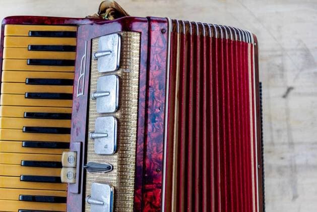  IMAGO Creative: Lokalhelden - Kunst und Kultur Antique red 120 bass accordion.covered with dust on wooden construction background., Old red 120 bass accordion covered with dust on wooden construction background. Musical instrument. Blowing instrument and bellows. Accordion for students., 11.05.2021, Copyright: xlecobronx Panthermedia29957695.jpg