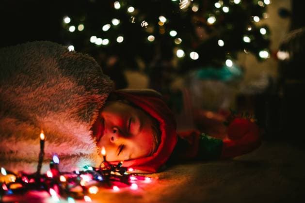 Boy child sleeps in cozy blanket and elf hat under Christmas tree Brian Head, Utah, United States CR_WVNP220901-1032136-01 ,model released, Symbolfoto
