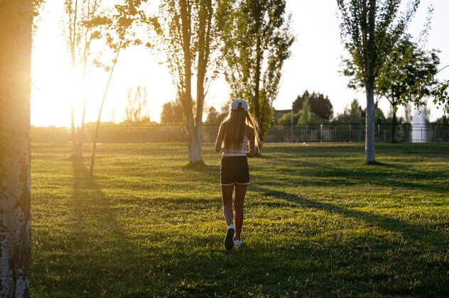 IMAGO Creative: Sommer, Sommertage im Stadtpark Full body back view of anonymous girl in cap strolling on grassy lawn in park with trees on summer evening, Model released JoseLuisCarrascosa_ID441_16966_120 Copyright: xJosexLuisxCarrascosax MR