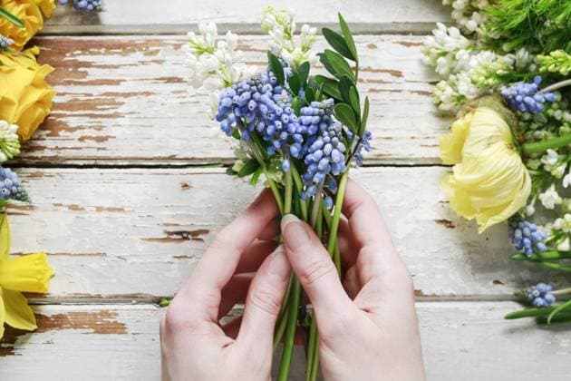 Florist at work: woman arranging bouquet of springtime flowers. Party decor  BEW1DAAB813