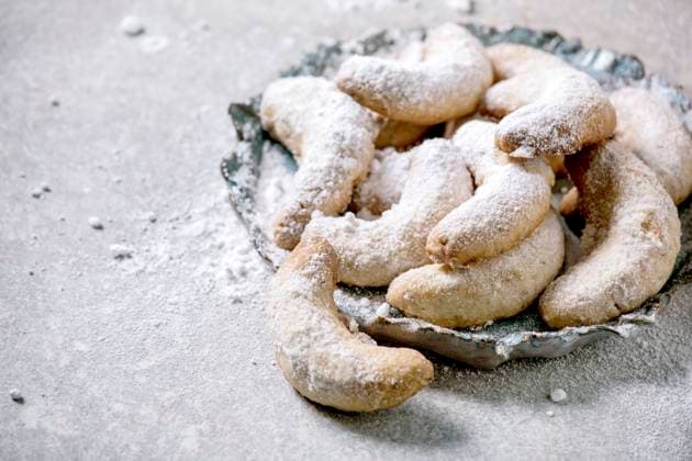 Christmas shortcrust cookies vanilla crescents with icing sugar Homemade traditional Christmas shortcrust cookies vanilla crescents with icing sugar. On ceramic plate over light grey background. Close up Copyright: xNatashaxBreenx NB221120-4
