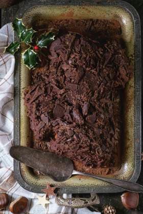 Homemade christmas chocolate yule log Whole homemade Christmas chocolate yule log with chestnuts cream on vintage tray with white textile rag and chestnuts, chocolate stars and holly branch over old wooden table. Rustic style. Top view Copyright: xNatashaxBreenx NB271016-1