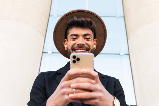 Creative Highlights Symbolbilder From below of young male in hat and formal wear browsing on cellphone in town, Model released DavidMunoz_BrianLifestyle_10 Copyright: xDavidxMunozx MR