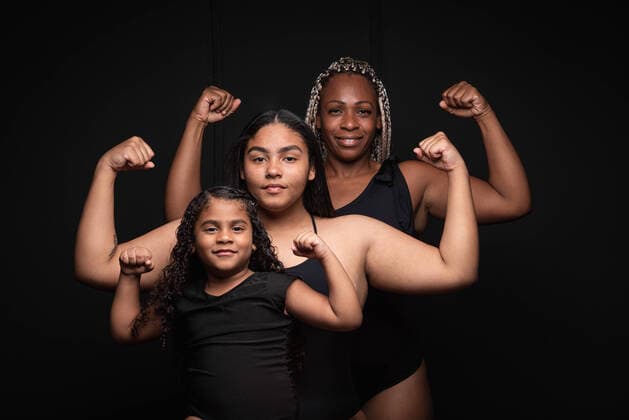 Creative Highlights Symbolbilder Group of sporty multiethnic multigenerational females showing muscles and looking at camera with confident smile against black background, Model released LeonardoBorges_RealWomen_12 Copyright: xLeonardoxBorgesx MR