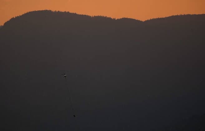 September 12, 2022, HOPE, BC, CANADA: A helicopter with a water bucket battling the Flood Falls Trail wildfire picks up water from the Fraser River, in Hope, B.C., Monday, Sept. 12, 2022. HOPE CANADA  - ZUMAc35_ 20220912_zaf_c35_210 Copyright: xDarrylxDyckx