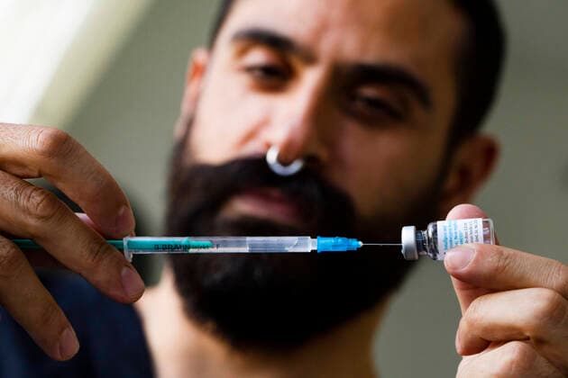 Laborant Jose (L) zieht mit einer Syringe den Impfstoff gegen Affenpocken und Pocken von einer Ampulle im Checkpoint Bln am Herrmannplatz in Berlin am 16. September 2022. Affenpockenimpfung im Checkpoint Bln *** Lab technician Jose L draws with a syringe the vaccine against monkeypox and smallpox from an ampoule at Checkpoint Bln at Herrmannplatz in Berlin on September 16, 2022 Monkeypox vaccination at Checkpoint Bln