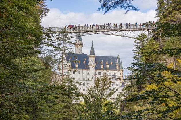 Blick von der Pöllatschlucht auf die Marienbrücke, sowie auf die Südfassade des Schlosses - Das Schloss Neuschwanstein in Hohenschwangau bei Füssen zählt zu den bekanntesten Sehenswürdigkeiten in Deutschland. Das für viele Touristen genannte Märchenschloss wurde von König Ludwig II als private Rückzugsort erbaut 19.09.2022 Schwangau Hohenschwangau Bayern Deutschland *** View from the Pöllat Gorge to the Marienbrücke, as well as the south facade of the castle The Neuschwanstein Castle in Hohenschwangau near Füssen is one of the most famous sights in Germany The fairy tale castle called for many tourists was built by King Ludwig II as a private retreat 19 09 2022 Schwangau Hohenschwangau Bavaria Germany