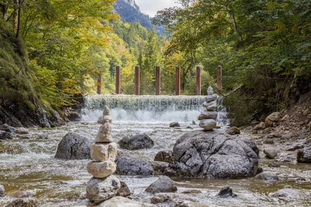 Kegelförmige Steinskulpturen in der Pöllat oberhalb der Pöllatschlucht. Die Wildholzrechen dienen als Hochwasserschutz - Das Schloss Neuschwanstein in Hohenschwangau bei Füssen zählt zu den bekanntesten Sehenswürdigkeiten in Deutschland. Das für viele Touristen genannte Märchenschloss wurde von König Ludwig II als private Rückzugsort erbaut 19.09.2022 Schwangau Hohenschwangau Bayern Deutschland *** Cone-shaped stone sculptures in the Pöllat above the Pöllat Gorge The wildwood rakes serve as flood protection Neuschwanstein Castle in Hohenschwangau near Füssen is one of the most famous sights in Germany The fairy-tale castle mentioned for many tourists was built by King Ludwig II as a private retreat 19 09 2022 Schwangau Hohenschwan