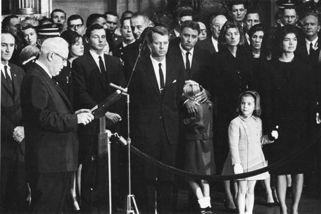 IMAGO History, Ermordung von US-Präsident John F. Kennedy in Dallas, 1963 RECORD DATE NOT STATED Chief Justice of the United States Earl Warren reads his tribute fo martyred President John F. Kennedy in ceremonies in the rotunda of the US Capitol. The late President s casket had been moved fro the White House to the Capitol to permit the public to pay its last respects. Jacuqline Kennedy stand at the right, holding daughter Caroline s hand. Left to right: Senator Mike Mansfield; Stephen Smith, a brother-in-law of the late President; President Johnson behind Robert Kennedy; Peter lawford, shown comforting 7-year-old daugher Sydney; Mrs. Lawford; President Kennedy s siters Patricia, Mrs. Kennedy and Caroline. November 24, 1963, Washington, DC. 1063_05_Kennedy_funeral