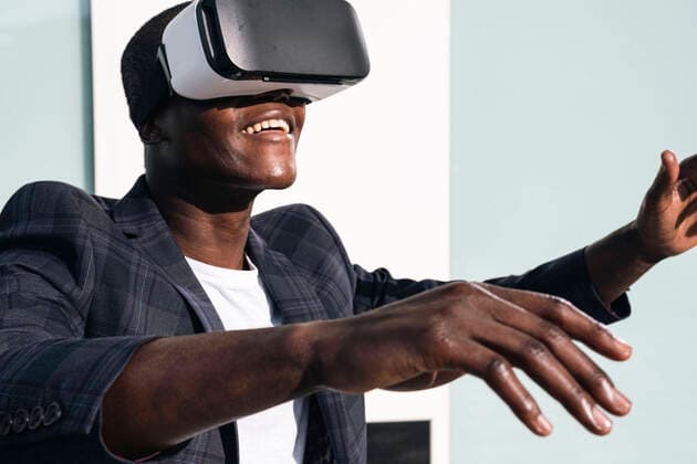 Creative Highlights Symbolbilder Happy young man wearing virtual reality glasses in front of wall model released, Symbolfoto, AMWF00323