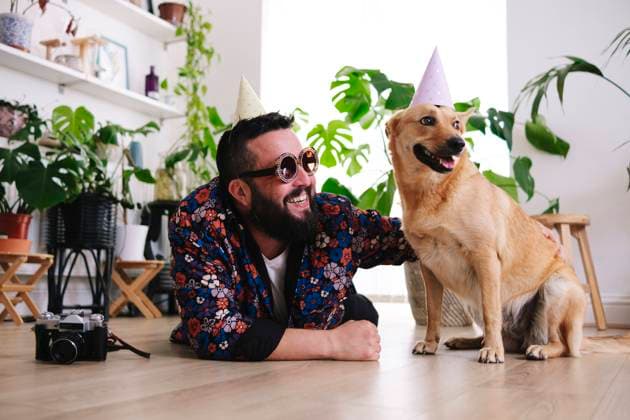 Happy man wearing sunglasses lying by pet dog at home model released, Symbolfoto property released, ASGF02676