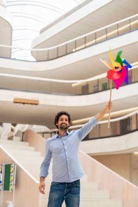 Smiling businessman with hand raised holding pinwheel toy model released, Symbolfoto property released, JOSEF12309