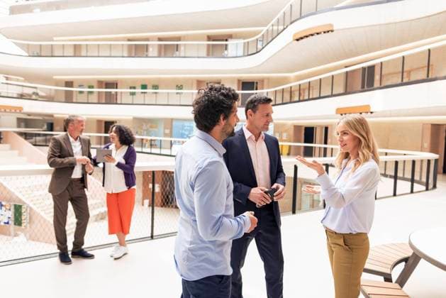 Businesswoman discussing strategy with colleagues in corridor model released, Symbolfoto property released, JOSEF12672