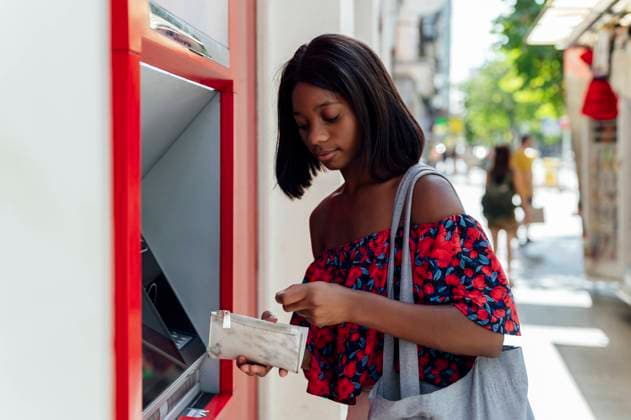 Young woman with purse standing at ATM model released, Symbolfoto, PGF01191