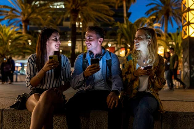 IMAGO Creative, Jahreszeit Herbst, Ferien Happy friends holding smart phones talking with each other at night model released, Symbolfoto, WPEF06329