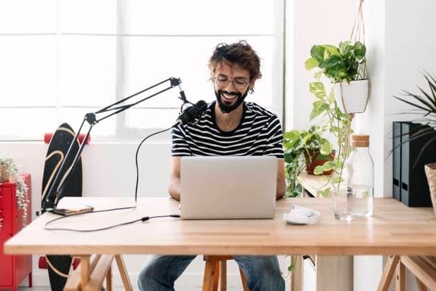 Happy man with microphone and laptop recording podcast in home studio model released, Symbolfoto property released, XLGF03046
