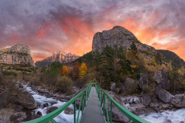 Narrow footbridge crossing fast mountain river in autumn evening sunset in Ordesa y Monte Perdido National Park in Huesca, Spain, Model released JuanLopez_ID697_25427_008 Copyright: xJuanxLopezx MR