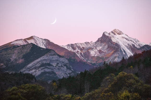 Breathtaking view of snowy mountain peaks and green forest located against sunset sky with crescent moon in evening in Ordesa y Monte Perdido National Park in Spain JuanLopez_ID709_25755_010 Copyright: xJuanxLopezx Model Released