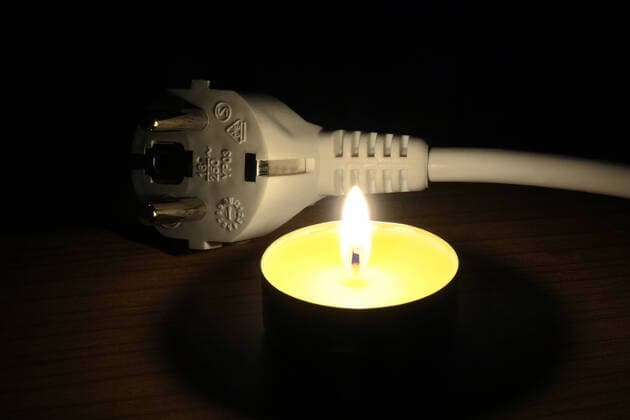 Teelicht und Elektrostecker Teelicht und Elektrostecker, 27.09.2022, Borkwalde, Brandenburg, Neben einem Elektrostecker steht ein brennendes Teelicht. *** Tealight and electric plug Tealight and electric plug, 27 09 2022, Borkwalde, Brandenburg, Beside an electric plug stands a burning tealight