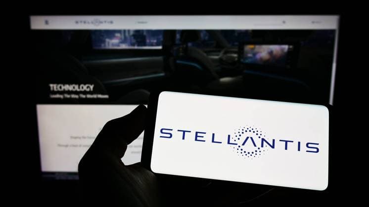 Person holding smartphone with logo of car manufacturer Stellantis N.V. on screen. Stuttgart, Germany - 06-25-2022: Person holding smartphone with logo of car manufacturer Stellantis N.V. on screen in front of website. Focus on phone display. Copyright: xZoonar.com TimonxSchneiderx zoonar_18838884