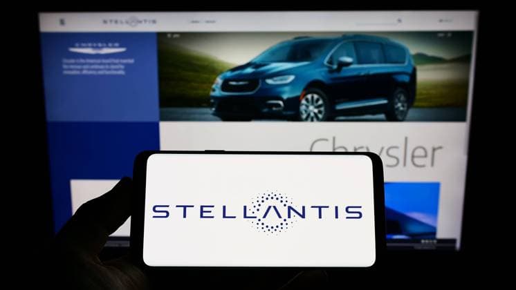 Person holding cellphone with logo of car manufacturer Stellantis N.V. on screen. Stuttgart, Germany - 06-25-2022: Person holding cellphone with logo of car manufacturer Stellantis N.V. on screen in front of business webpage. Focus on phone display. Copyright: xZoonar.com TimonxSchneiderx zoonar_18838926
