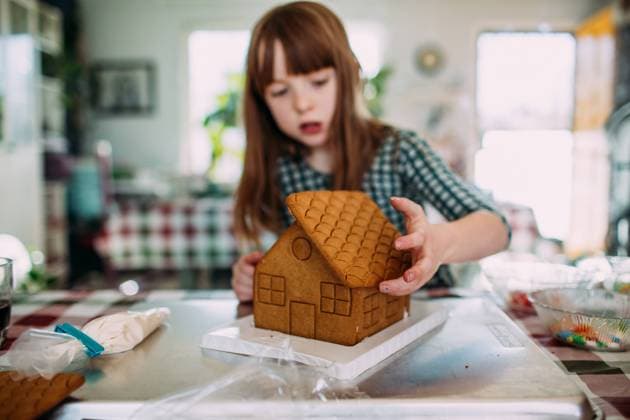 Young girl building a gingerbread house at the dining room table Denver, CO, United States CR_JEMI210628-607452-01 ,model released, Symbolfoto