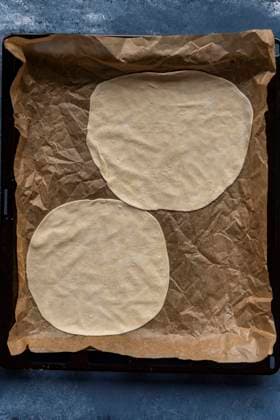 Turkish lahmacun dough portions on a parchment paper lined baking sheet Copyright: xYusufxRizaxGunaydinx YG100720-6