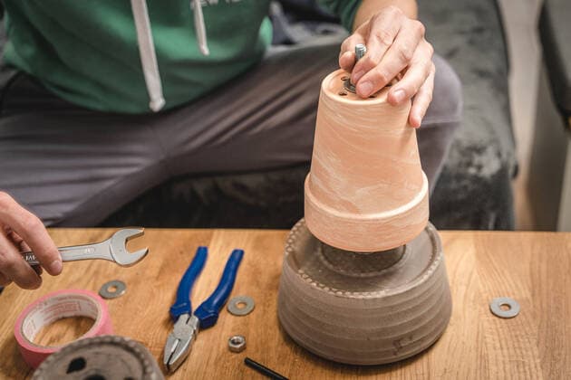 30 September 2022: young man, DIY build tealight heater at home to save electricity and gas. homemade tealight stove, DIY heater from plant pot and tealight candles *** junger Mann, Heimwerker baut zuhause eine Teelichtheizung um Strom und Gas zu sparen. selbstgebauter Teelicht Ofen, DIY Heizung aus Pflanzentopf und Teelicht Kerzen