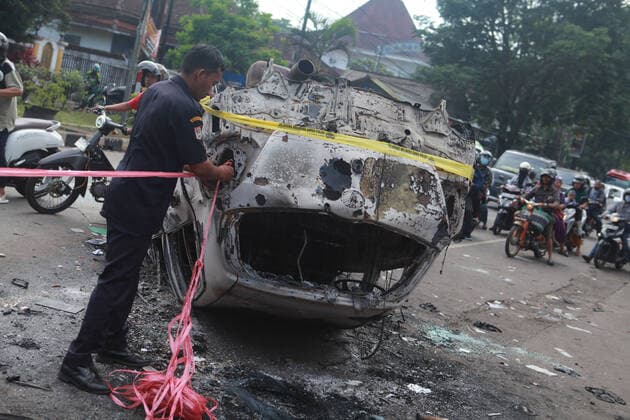 News Bilder des Tages (221002) -- MALANG, Oct. 2, 2022 -- A police officer ties a rope on the wreckage of a burned car outside the Kanjuruhan Stadium in Malang of East Java province, Indonesia, Oct. 2, 2022. At least 129 people were killed and 180 others injured after a stampede and clashes at a football match in Indonesia s Malang, East Java province on Saturday evening, Indonesian police said on Sunday. Provincial police chief Nico Afinta said at a press conference that the chaos happened on late Saturday at the Kanjuruhan Stadium in Malang regency right after Arema Malang club lost to Persebaya Surabaya in the Indonesian Liga 1 football contest. (Photo by Xinhua) INDONESIA-MALANG-FOOTBALL MATCH-STAMPEDE-CLASH-CASUALTIES BayuxNovanta 