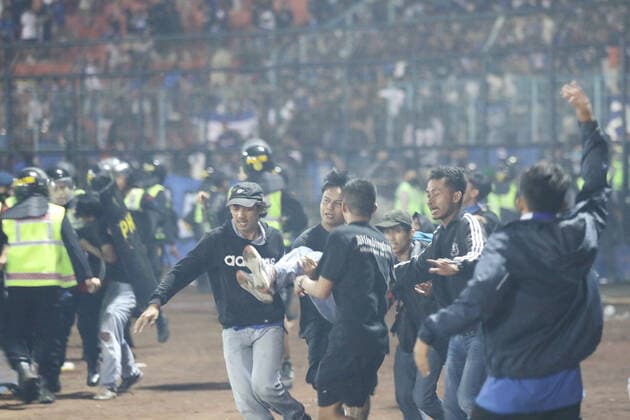 Indonesien, Massenpanik während eines Fußballspiels in Provinz Ost-Java (221002) -- MALANG, Oct. 2, 2022 -- People transfer an injured man at the Kanjuruhan Stadium in Malang of East Java province, Indonesia, Oct. 1, 2022. The death toll in a crowd stampede at a football match in Indonesia s East Java province has reached 174 as of Sunday afternoon, according to the province s deputy governor Emil Dardak. The tragedy occurred on Saturday night at the Kanjuruhan Stadium in Malang of Indonesia s East Java province, right after Arema Malang club lost to Persebaya Surabaya in an Indonesian league football match. (Photo by Xinhua) INDONESIA-MALANG-FOOTBALL MATCH-STAMPEDE-CLASH-CASUALTIES BramxYudha 