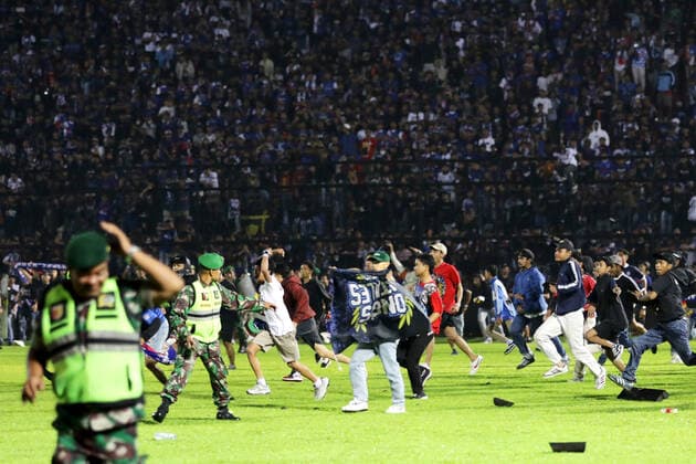 (221002) -- MALANG, Oct. 2, 2022 -- People enter the football pitch at the Kanjuruhan Stadium in Malang of East Java province, Indonesia, Oct. 1, 2022. The death toll in a crowd stampede at a football match in Indonesia s East Java province has reached 174 as of Sunday afternoon, according to the province s deputy governor Emil Dardak. The tragedy occurred on Saturday night at the Kanjuruhan Stadium in Malang of Indonesia s East Java province, right after Arema Malang club lost to Persebaya Surabaya in an Indonesian league football match. (Photo by Xinhua) INDONESIA-MALANG-FOOTBALL MATCH-STAMPEDE BramxYudha 