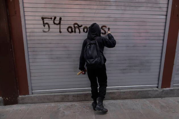 54th Anniversary Of The Tlatelolco Massacre In Mexico City A member of the Black Bloc paints a metal curtain while demonstrators march to the Zocalo in Mexico City, on the occasion of the 54th anniversary of the Tlatelolco Massacre that took place on 2 October 1968 in the square. Mexico City Mexico City Mexico  Copyright: xGerardoxVieyrax originalFilename: vieyra-notitle221002_npTiU.jpg