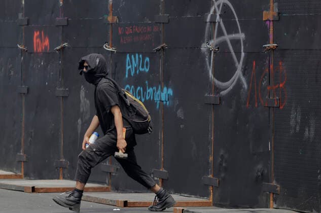 54th Anniversary Of The Tlatelolco Massacre In Mexico City A member of the Black Bloc painted graffiti outside the National Palace while demonstrators protested in the Zocalo in Mexico City, on the occasion of the 54th anniversary of the Tlatelolco Massacre that took place on 2 October 1968 in the square. Mexico City Mexico City Mexico  Copyright: xGerardoxVieyrax originalFilename: vieyra-notitle221002_npYfm.jpg