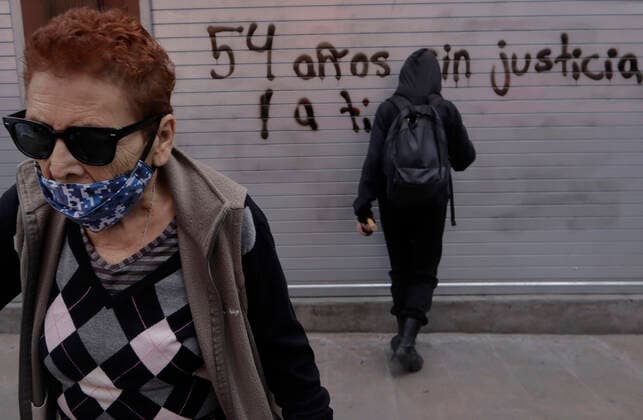 54th Anniversary Of The Tlatelolco Massacre In Mexico City An elderly woman crosses paths with a member of the Black Bloc who paints a metal curtain while demonstrators march to the Zocalo in Mexico City, on the occasion of the 54th anniversary of the Tlatelolco Massacre that took place on 2 October 1968 in the square. Mexico City Mexico City Mexico  Copyright: xGerardoxVieyrax originalFilename: vieyra-notitle221002_npGHY.jpg