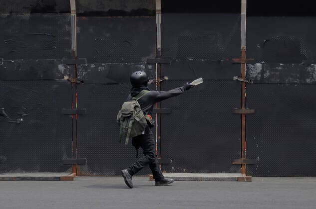 54th Anniversary Of The Tlatelolco Massacre In Mexico City A member of the Black Bloc throws a bottle outside the National Palace while demonstrators protest in the Zocalo in Mexico City, on the occasion of the 54th anniversary of the Tlatelolco Massacre which took place on 2 October 1968 in the square. Mexico City Mexico City Mexico  Copyright: xGerardoxVieyrax originalFilename: vieyra-notitle221002_npgSJ.jpg