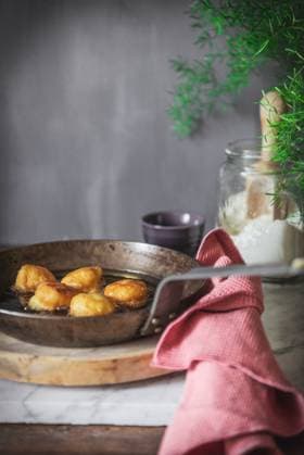 Pan with oil frying nun s puffs bites placed on table in kitchen at home PatriciaGarcia_ID929_34026_004 Copyright: xPatriciaxGarciax Model Released