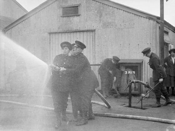 Ministry of Information First World War Official Collection Fire girls at work with hose and hydrant at a National Shell Filling Factory. Copyright: xpiemagsx minofinfopieww04102022-1401 !ACHTUNG AUFNAHMEDATUM GESCHÄTZT!