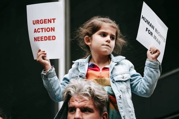 October 16, 2022, New York, United States: A kid holds placards expressing her opinion during an emergency rally in response to Evin prison fire. Members of Iranian community and allies gather outside of the permanent mission of Iran to UN in response to reports of a fire at the notorious Evin prison. Evin prison is known for housing political prisoners. New York USA - ZUMAs197 20221016_zaa_s197_173 Copyright: xOlgaxFedorovax