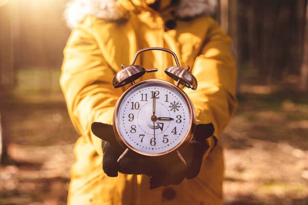 28 October 2022: Alarm clock in the hand of a woman, symbolic image time change from daylight saving time to winter time. The clock is set back to 2 o clock on the night of October 30 PHOTOMONTAGE *** Wecker in der Hand einer Frau, Symbolbild Zeitumstellung von Sommerzeit auf Winterzeit. Die Uhr wird in der Nacht vom 30 Oktober auf 2 Uhr zurückgestellt FOTOMONTAGE