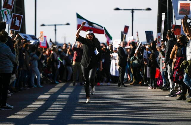 October 29, 2022, Ottawa, ON, CAN: A demonstrator raises their fist as they chant along the Alexandra Bridge joining Ottawa and Gatineau, Que. during a worldwide human chain organized by the Association of Families of Flight PS752 Victims in solidarity with antigovernment protesters in Iran, on Saturday, Oct. 29, 2022. Ottawa CAN  - ZUMAc35_ 20221029_zaf_c35_084 Copyright: xJustinxTangx