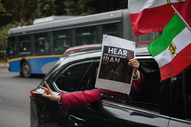 October 29, 2022, Vancouver, British Columbia, Canada: A vehicle drives over the Lions Gate Bridge in Vancouver, British Columbia, with a person holding a sign out of the window that reads Ã¢â‚¬oeHear the voices from IranÃ¢â‚¬Â..The protest brought people together on the Lions Gate Bridge to form a human chain Vancouver Canada - ZUMAw171 20221029_znp_w171_006 Copyright: xRyanxWalterxWagnerx
