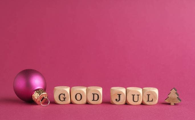 Small wooden blocks with the inscription God Jul, Scandinavian Merry Christmas, purple background, minimalist wooden Christmas decoration