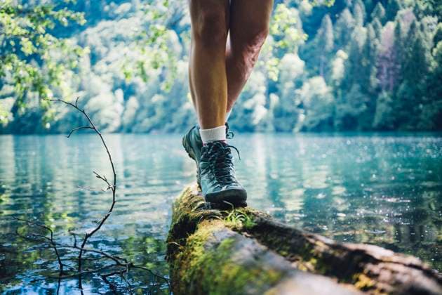 Woman wearing hiking boot walking on tree log by Lake Levico model released, Symbolfoto, GIOF15589