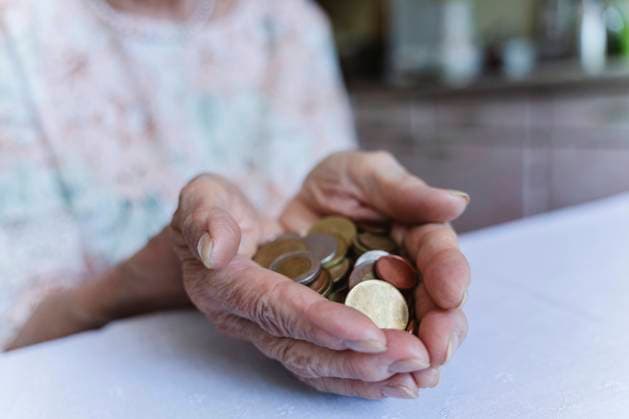 Senior woman holding coins over table at home model released, Symbolfoto property released, OSF00971