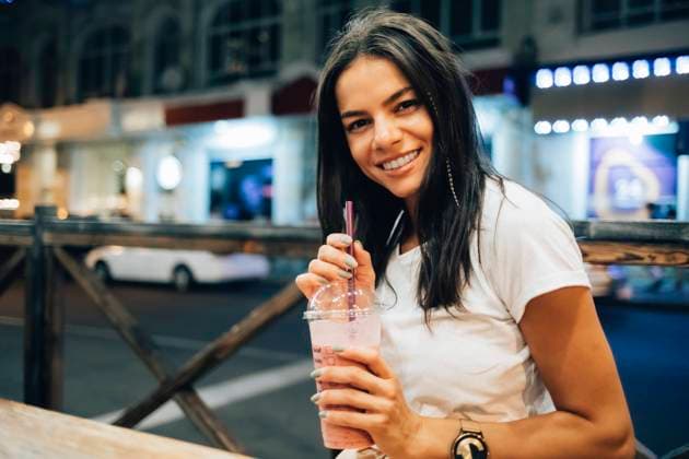 IMAGO Creative, Jahreszeit Sommer, Sommer in der Stadt Happy beautiful woman with smoothie at sidewalk cafe model released, Symbolfoto, OYF00801