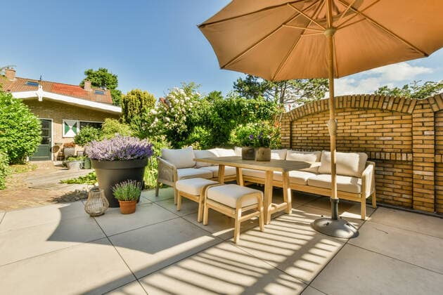 Terrace of a house with a sofa and umbrella under a blue sky with clouds, Property released ProCreators_ID664_24382_011 Copyright: xProxCreatorsx Model Released