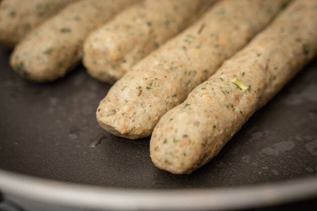 10 February 2022: Vegan sausage in a pan. Meat substitute made from pea protein and wheat protein. Bratwurst in a frying pan *** Vegane Bratwurst in einer Pfanne. Fleischersatz aus Erbsenprotein und Weizen Protein. Bratwürste in einer Bratpfanne